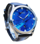 Wristwatch with cobalt blue face and black strap facing to the right on a white background