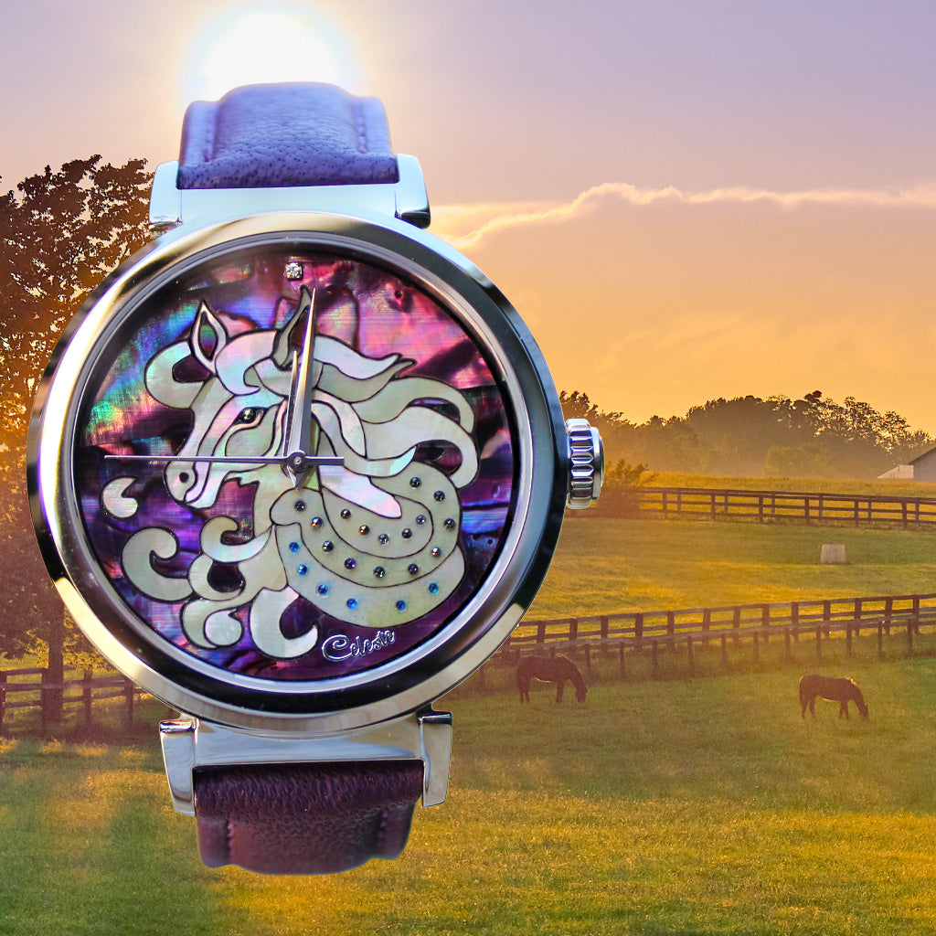 Watch with horse design on a field with horses at sunset